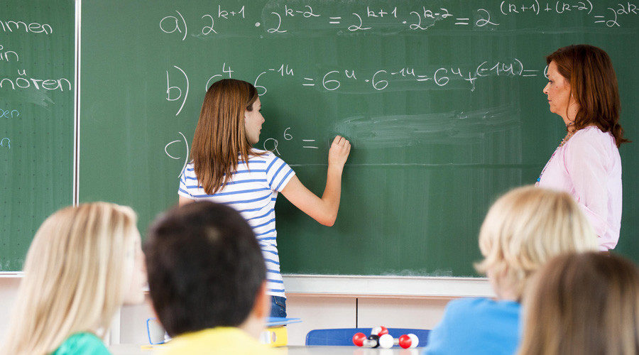 Student doing math on classroom chaulkboard