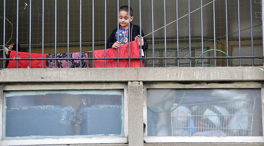 A child plays behind railings on the Robin Hood Gardens estate in Poplar, in East London