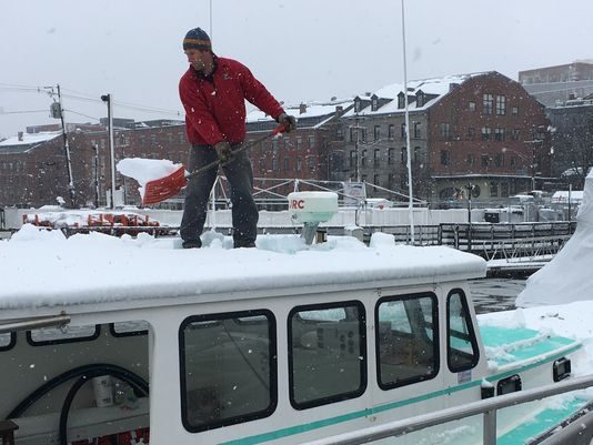 Tom Martin shovels snow off his boat on April 1, 2017 in Portland, Maine.