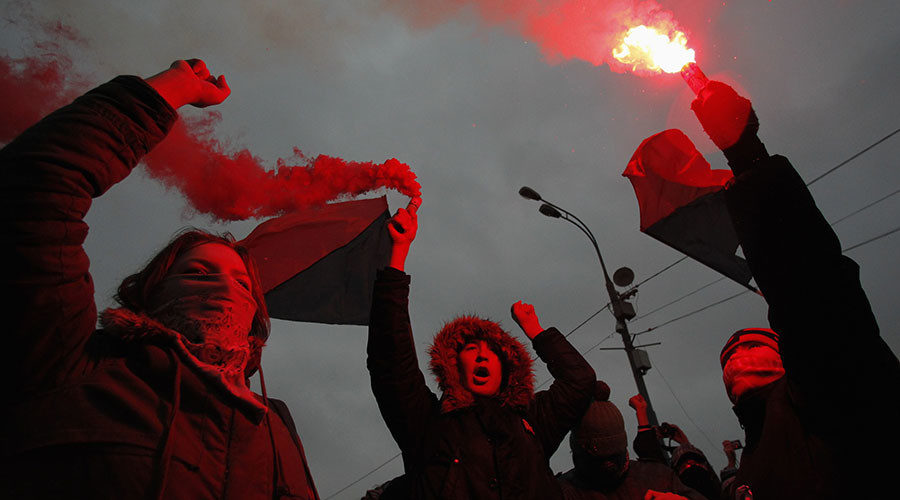 Members of a local anarchist movement burn flares during a sanctioned rally in Bolotnaya square in Moscow
