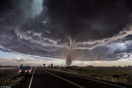 Click to enlarge A slow moving tornado dumbfounds a car-full of spectators.