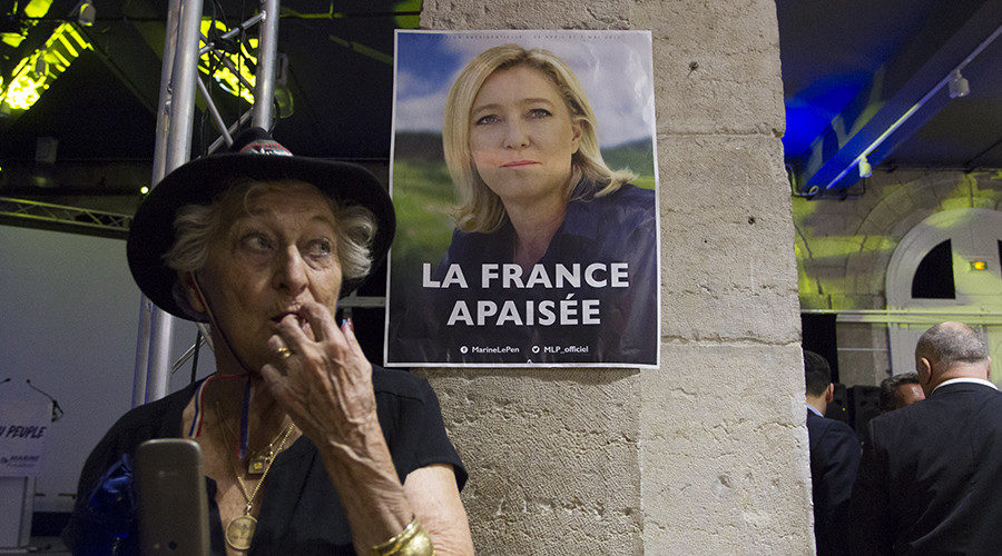 woman in front of Marine Le Pen election poster