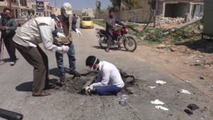 Photograph of men in Khan Sheikdoun in Syria, allegedly inside a crater where a sarin-gas bomb landed