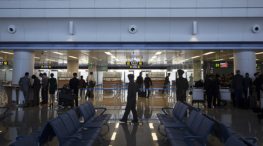 Security officials and ground staff check passengers at Pyongyang's airport