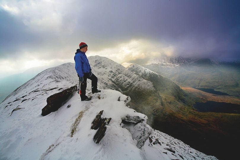 Mountaineer Sean Hennessy and spring snow fall on the summit of Cnoc an Chuillin on the McGillycuddy Reeks Killarney (stock)