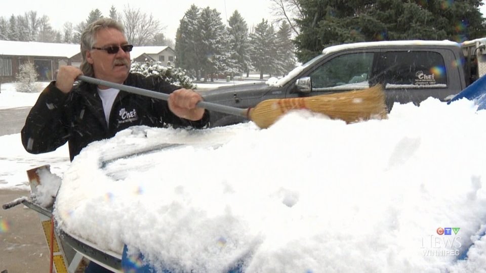 Bert Toews cleans the windshield of his car in Winnipeg, Man. 