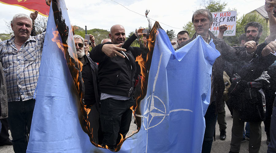 Click to enlarge Protesters burn the NATO flag