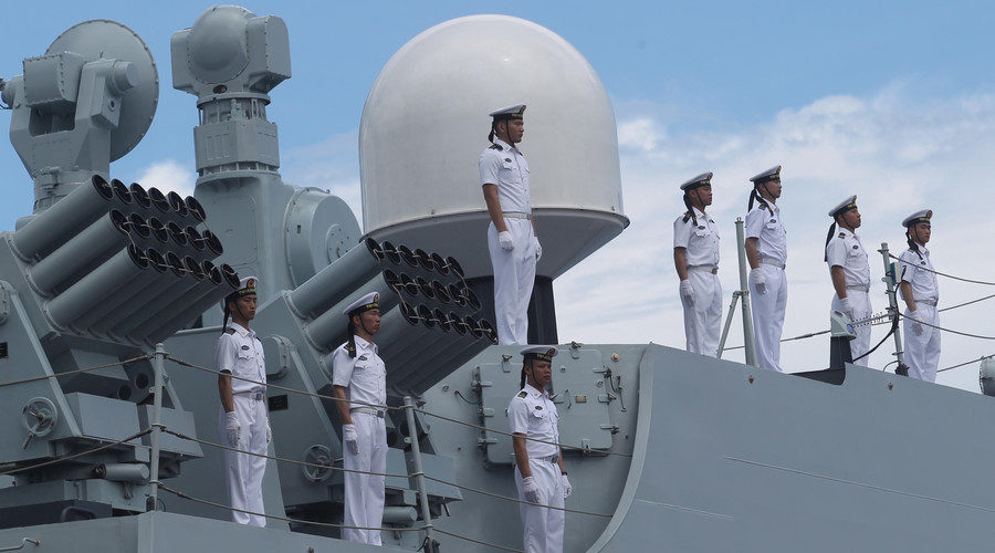 Chinese sailors stand at attention onboard a Chinese naval ship