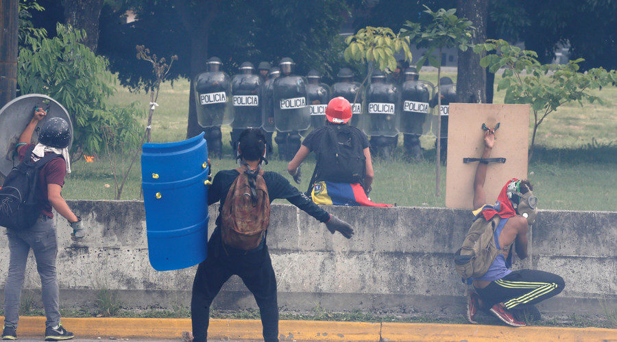 Protesters confront police after breaking a fence surrounding an air force base,Caracas