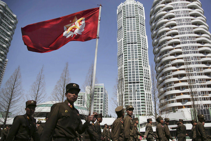 Click to enlarge North Korean soldiers carry the Korean People's Army flag