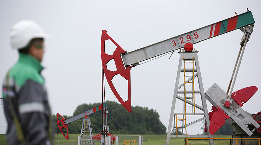 A worker looks at a pump jack at an oil field in Bashkortostan, Russia