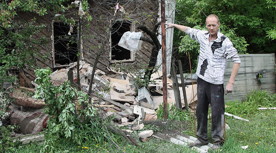 A man near a house damaged by shelling in Kuibyshevsky District of Donetsk