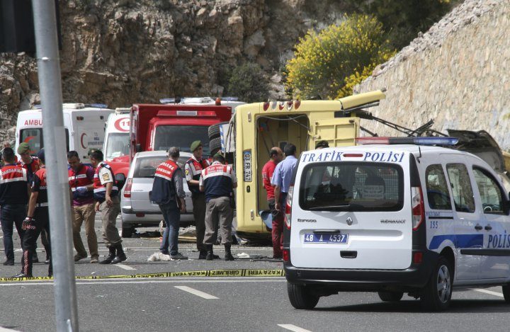 Turkish police officers work next to an overturned bus at the scene of a traffic accident, near Marmaris, western Turkey, on May 13, 2017