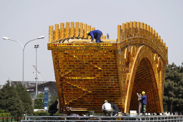 Click to enlarge Workers install wires on a 'Golden Bridge of Silk Road'