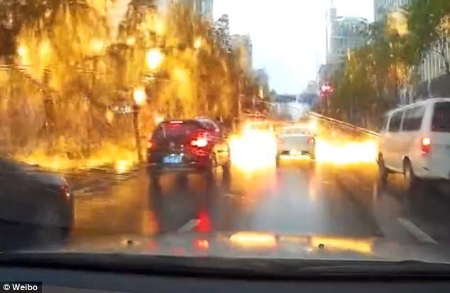 Click to enlarge Fiery sparks fell onto a busy road in China after it was hit by a flash of lightning on May 11
