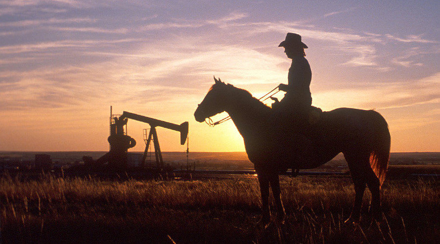 Cowboy watching oil rig