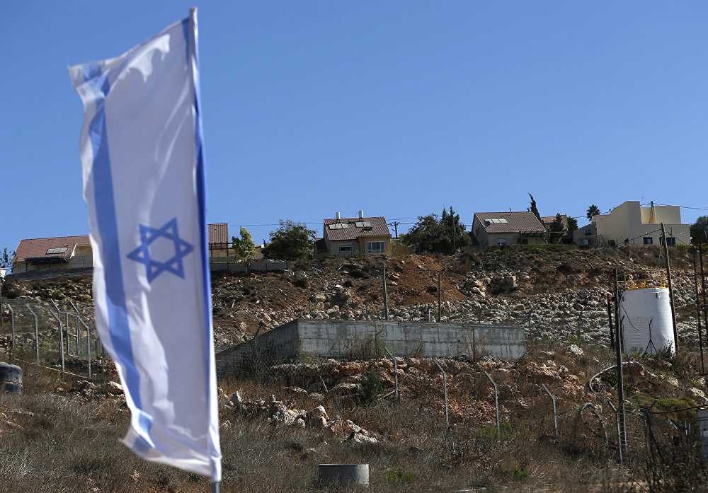 Israeli national flag flying next to an Israeli building site of new housing units in the Jewish settlement of Shilo