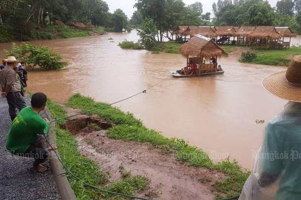 Click to enlarge Residents try to stop a restaurant's straw huts from floating away in the swollen Kwai Noi River in Wat Bot district of Phitsanulok on Wednesday.