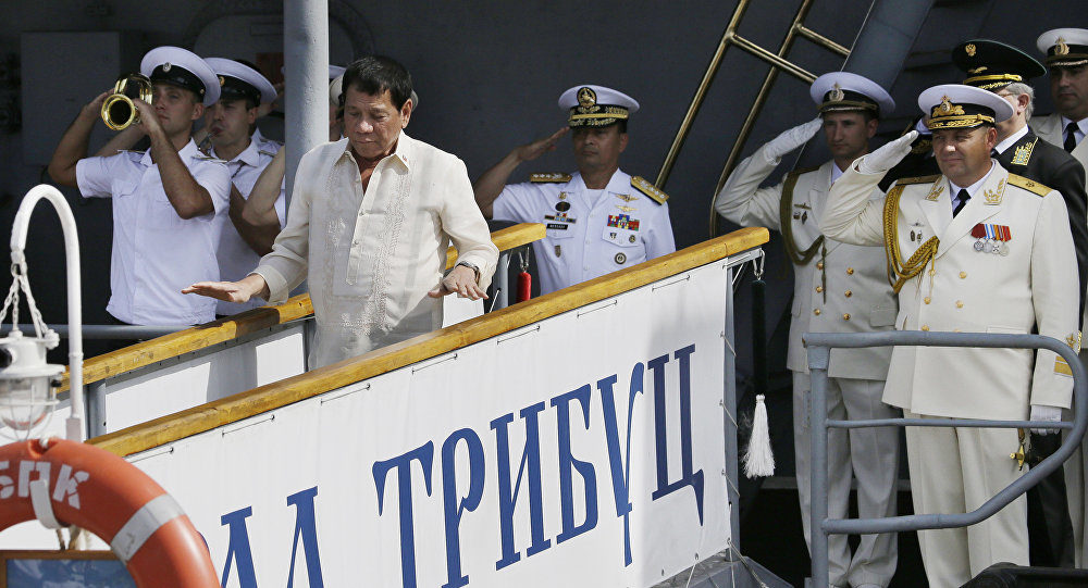 Click to enlarge Russian Navy and a Philippine officer salute as Philippine President Rodrigo Duterte