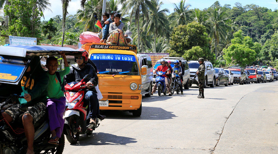 Click to enlarge A government troop stands on guard checking vehicles evacuating residents from their hometown of Marawi city in southern Philippines, as it drives past a military checkpoint in Pantar town, Lanao Del Norte