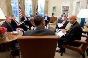 Director of National Intelligence James Clapper (right) talks with President Barack Obama in the Oval Office, with John Brennan and other national security aides present