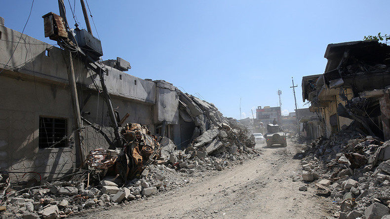 Click to enlarge Iraqi forces' vehicle drives past destroyed buildings in the Mosul al-Jadida area