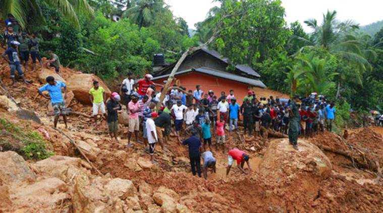 Sri Lankans watch military rescue efforts at the site of a landslide in Bellana village in Kalutara district, Sri Lanka, Friday, May 26, 2017.