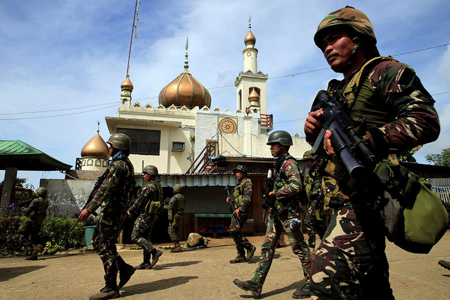 Government troops walk past a mosque before their assault with insurgents from the so-called Maute group