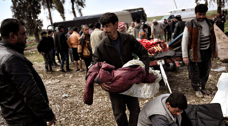 A man carries the body of an Iraqi child who was killed in an airstrike