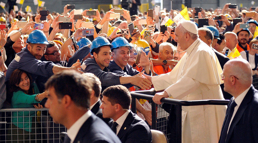 Pope Francis shakes hands with ILVA steel plant workers as he leaves the plant during his pastoral visit in Genoa