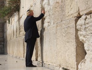Donald Trump places a prayer in-between the stone blocks of the Western Wall 