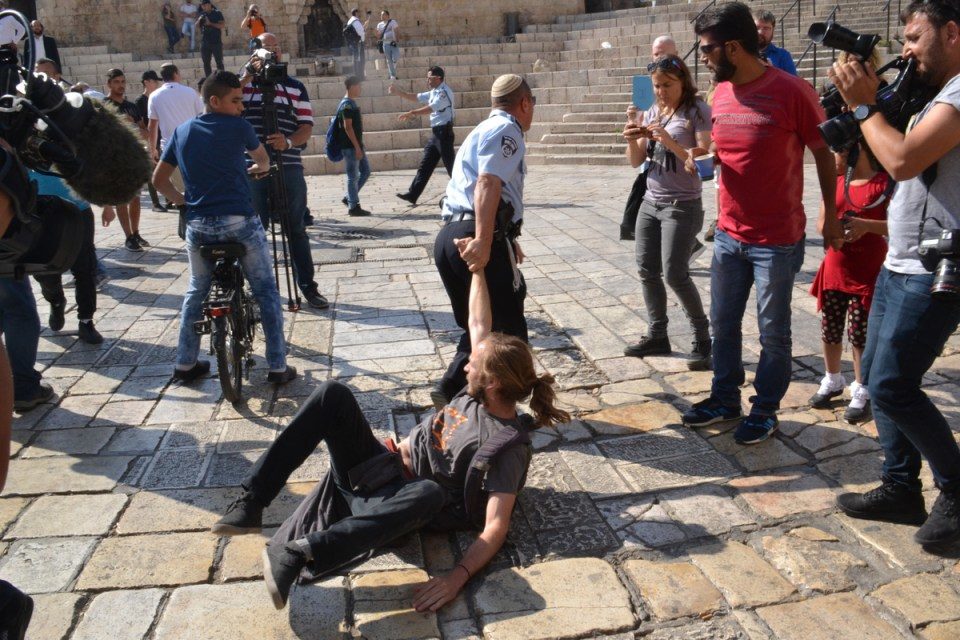 Jeewish police forcefully clearing the plaza of onlookers and journalists