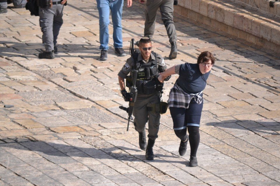 Jeewish police forcefully clearing the plaza of onlookers and journalists