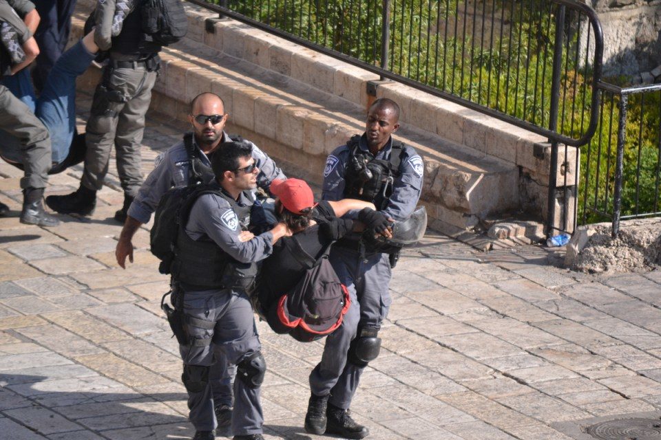 Jeewish police forcefully clearing the plaza of onlookers and journalists