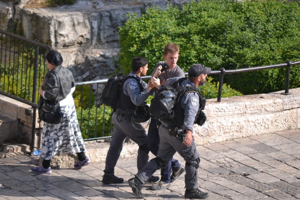 Jeewish police forcefully clearing the plaza of onlookers and journalists