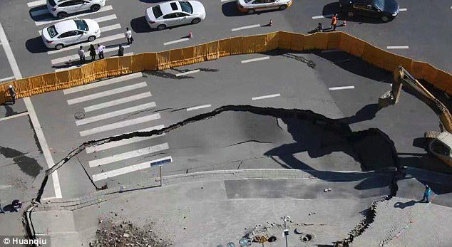 Click to enlarge Workers set up barriers for road safety and make sure no cars crashing into the cave-in
