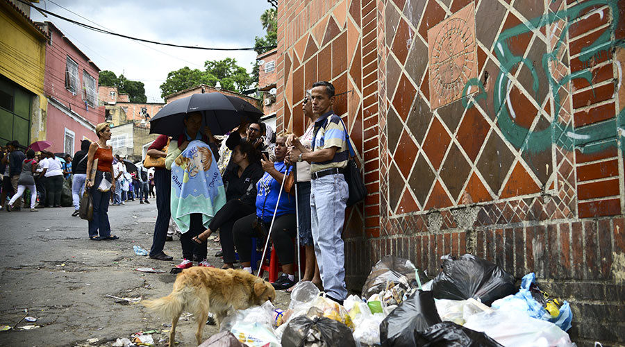 Click to enlarge People line up to buy basic food and household Caracas, Venezuela.