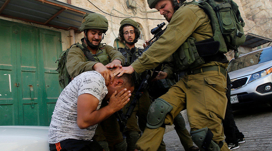 Israeli soldiers detain a Palestinian