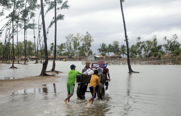 Click to enlarge People in the Chittagong walk to safety after Cyclone Mora