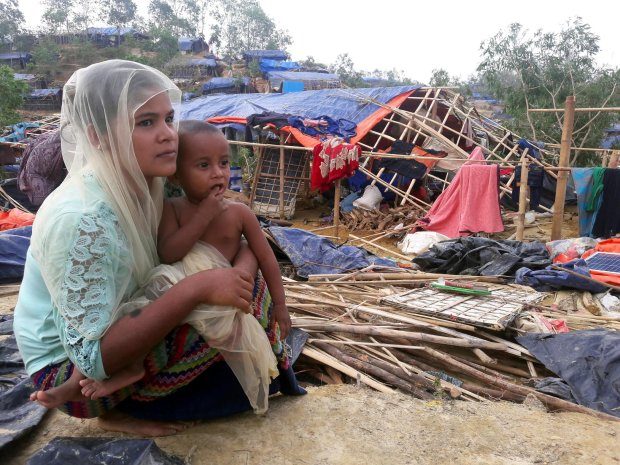 A mother and her young child sit among the ruins of their home in the Rohingya refugee camp in Cox’s Bazar 