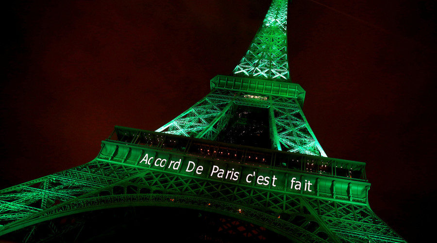 The Eiffel tower is illuminated in green with the words 