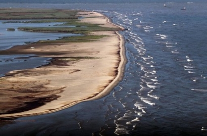 Waves wash oil onto the beach in May 2010 near the south pass of the Mississippi River into the Gulf 