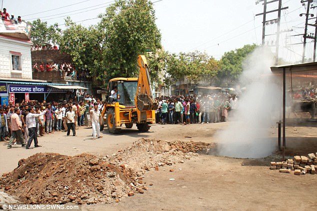 Click to enlarge The sinkhole opened up in front of a shop dragging in a father and son. Smoke could be seen coming from the hole which opened up as a result of raging underground fires