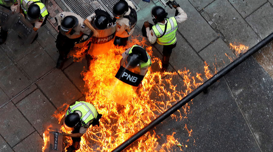 Riot security forces members catch fire at a rally against Venezuelan President Nicolas Maduro's government in Caracas