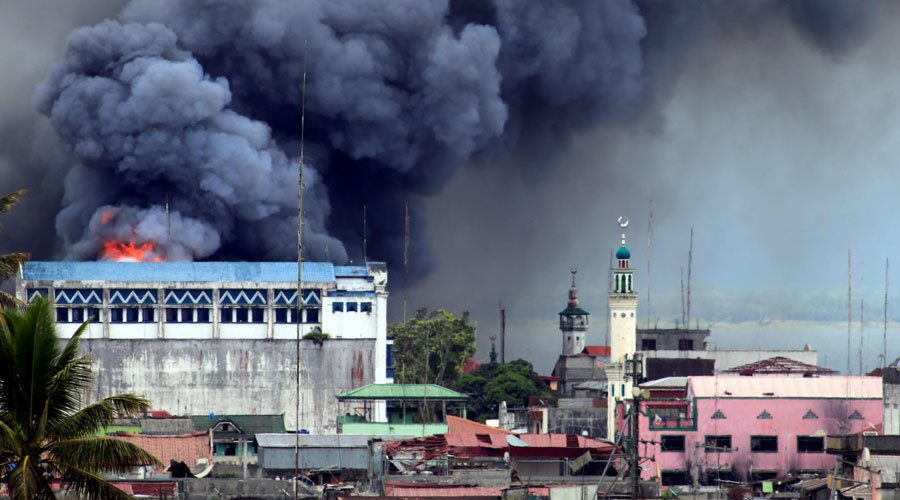 Black smoke comes from a burning building in a commercial area of Osmena street in Marawi city