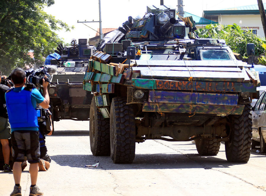 rmoured personnel carrier (APC) drives along the road of Amai Pakpak