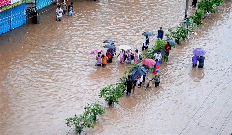 People make their way through a flooded street after heavy rainfall in Guwahati, Assam on Tuesday. 