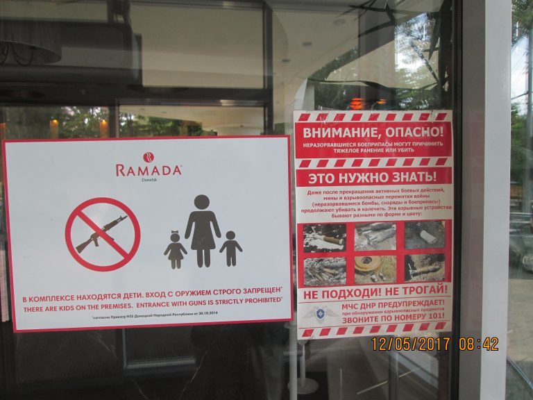 Still at war – no guns, and beware unexploded munitions notice at the gates of a local store in Donetsk