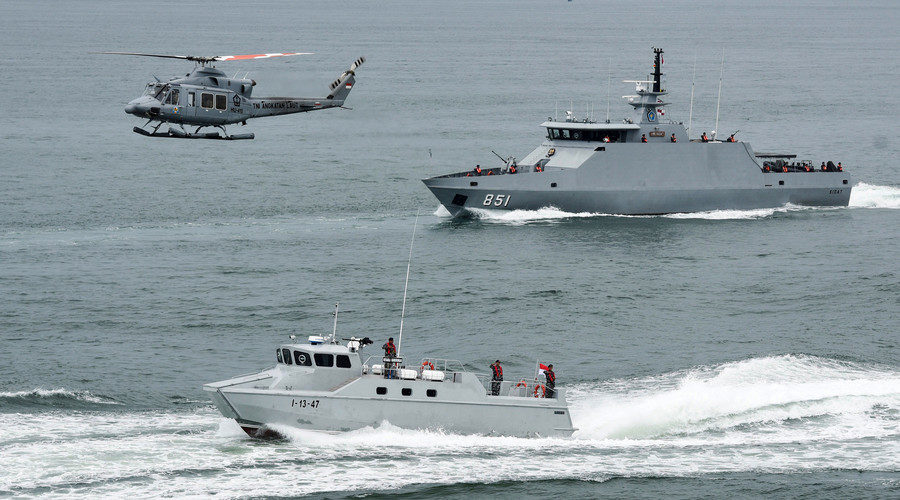 Click to enlarge Indonesia navy soldiers on warship and helicopter are seen during the launch of coordinated patrols to beef up security