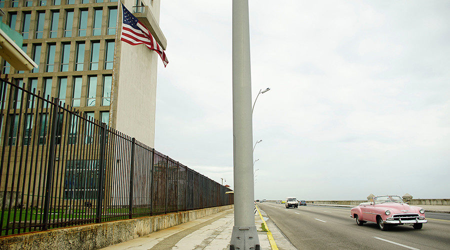 Click to enlarge A vintage car drives past the U.S. Embassy in Havana